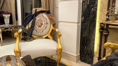 A gun placed on a chair at another of the apartments the BBC saw inside