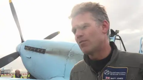 Matt Jones looking to the left with the Spitfire behind him.