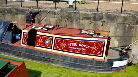 Red narrowboat with traditional decoration 