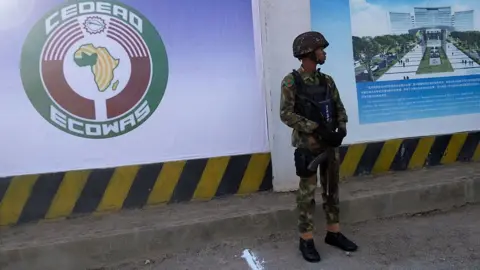 AFP via Getty Images An armed soldier standing outside headquartes of the Economic Community of West African States (Ecowas) in Abuja, Nigeria 