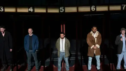 Jason Roberts Five actors stand side by side on stage during a production of Boys from the Black Stuff.