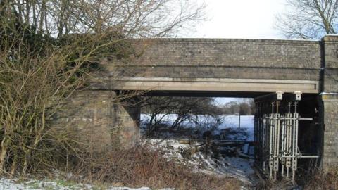 Congham Bridge in December 2009 showing a tree growing into wingwall and propping of the deck