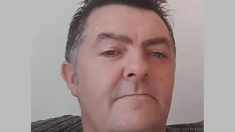 PSNI Middle-aged man with grey short hair looking into the camera 