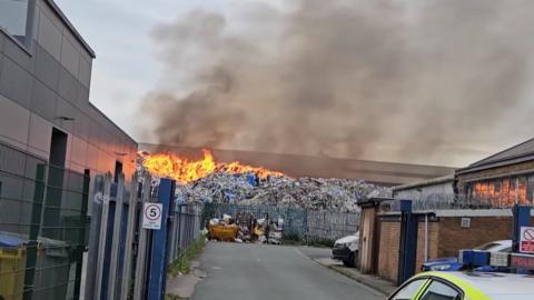 A pile of waste on fire at a Huyton industrial estate