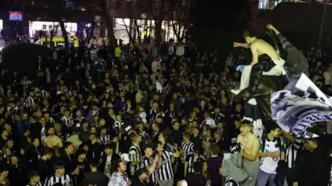 Reuters Newcastle United fans celebrate outside St James' Park after winning the Carabao Cup