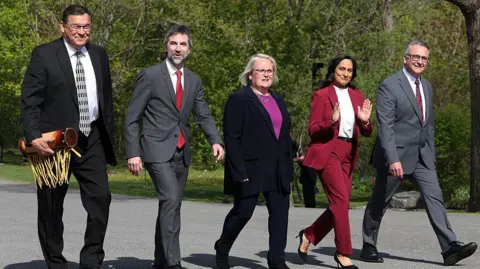 Getty Images Buckley Belanger, Canada's secretary of state for rural development, from left, Steven Guilbeault, Canada's identity and culture minister, Jill McKnight, Canada's veterans affairs minister, Anita Anand, Canada's foreign affairs minister, and Heath MacDonald, Canada's agriculture minister, arrive for a swearing-in ceremony at Rideau Hall in Ottawa. They are all smiling.