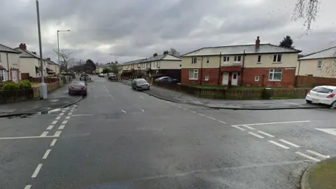 The junction of residential streets Arnhem Road and Fishwick Parade in Preston taken on a cloudy day.