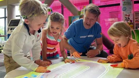 Children with John Ramsay playing on the interactive storytelling projector