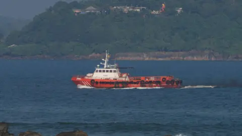 A vessel sails off the Galle coast after a submarine attack on the Iranian military ship