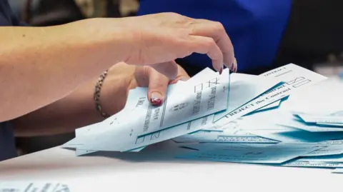 Getty Images Light blue coloured ballot papers being counted as the Boeing union tallies votes on the latest Boeing contract offer at the District Lodge 751 Union Hall in Seattle, Washington on 4 November, 2024.