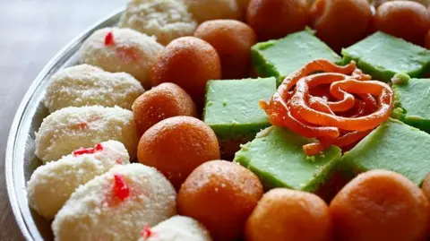 A platters of Indian desserts, including Juile (left to right), Gulab Jamun, Mix Burfi and Jalebi 