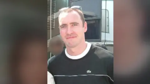BBC Paul Doyle wears a black t-shirt and sunglasses on his head. 