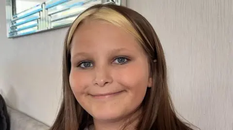 Collect of Mia Lucas, 12, wearing a pink jumper and smiling