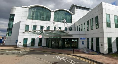 Main entrance to Ashford Hospital building, reception doors, street with no parking marking