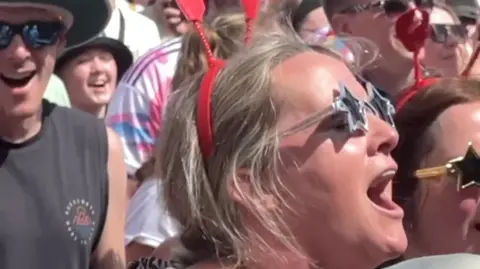 Crowd singing in the sunshine