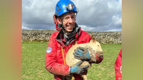 A volunteer holding a lamb