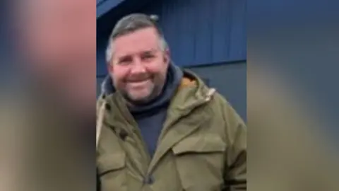 Simon Geary wearing a jacket and a navy blue hoodie