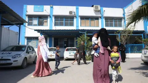 AFP Palestinians locomotion extracurricular an Unrwa aesculapian centre successful Khan Younis, successful nan confederate Gaza Strip (29 October 2024)