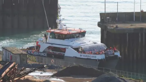 PA Media A group of people thought to be migrants are brought in to the Border Force compound in Dover, Kent, onboard a Border Force vessel.