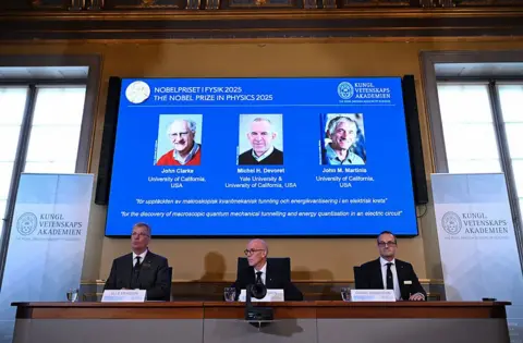 Getty Images Olle Eriksson, Chair of the Nobel Committee for Physics, Hans Ellegren, Secretary General of The Royal Swedish Academy of Sciences, and Goeran Johansson, Member of the Nobel Committe for Physics, address a press conference to announce the winners of the 2025 Nobel Prize in Physics at the Royal Swedish Academy of Sciences in Stockholm, Sweden,