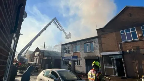 Leicestershire Fire and Rescue Service Firefighters dealing with shop fire on Marjorie Street in Leicester