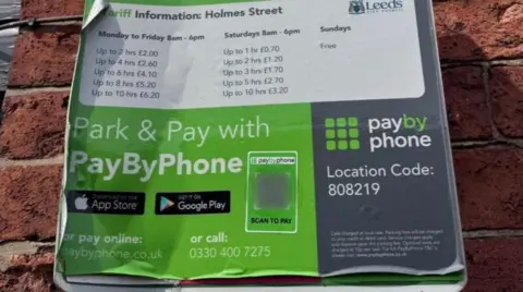 Leeds City Council A notice with parking information on. It includes a barcode, contact details and tariffs. 