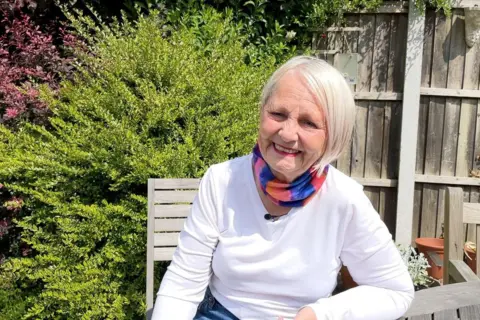 Jane Phillips sitting in her garden in Stapleford