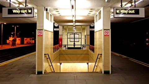 Getty Images File image showing signs and an illuminated staircase at Finchley Road tube station