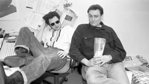 Martyn Goodacre/Getty James Brown (left) and Tim Southwell (right)  holding a mock-up of the first ever Loaded magazine in 1994 in a black and white photo