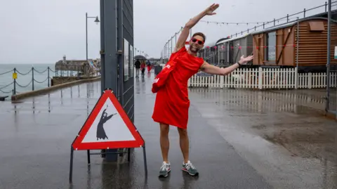 Andrew Aitchison/Getty Images Hundreds of Kate Bush fans came together today wearing red floaty dresses on Folkestone's Harbour Arm to dance to her most iconic song, Wuthering Heights on the 20th of July 2025 in Folkestone, United Kingdom. 