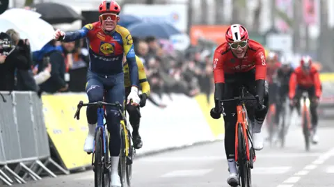 Mads Pedersen punches the air in delight after he wins stage six of Paris-Nice.