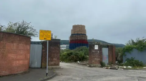 The bonfire that's built with red, white and blue pallets. The entrance of the building has wood and debris on the street.