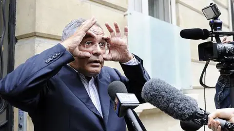 JOHANNA LEGUERRE/AFP O advogado franco-libanês Robert Bourgi responde a perguntas de jornalistas do lado de fora da estação de rádio Europe 1 em Paris, em 12 de setembro de 2011.