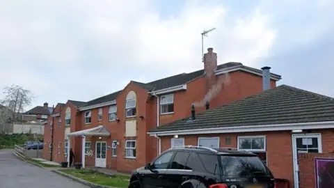 Google Streetview image of Forest Manor Care Home in Ashfield, a modern two storey red brick building with a small amount of parking around