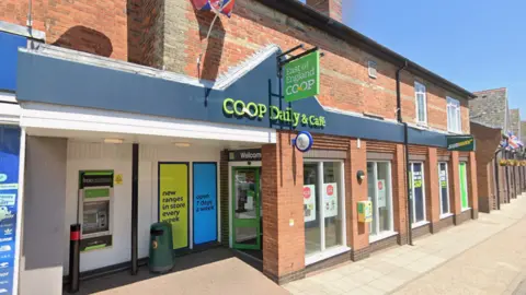 Google A general view of a Co-op supermarket on a High Street on a sunny day. The name of the store is above the entrance.