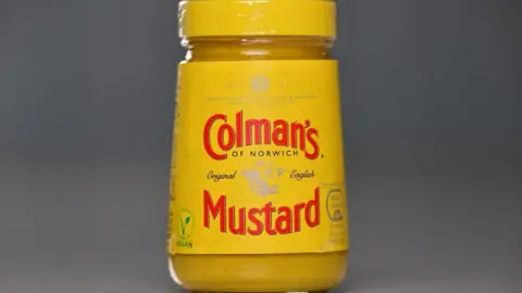 Getty Images A glass jar of Colman's mustard. A yellow label on the condiment says, Colman's of Norwich, original English Mustard.