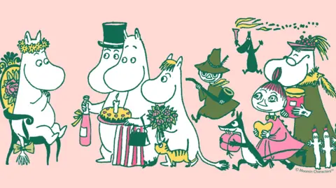 Moomin Characters™ A cartoon image of five Moomins with big noses celebrating with cake and drinks. Other creatures like the yellow cat and the witch join them.