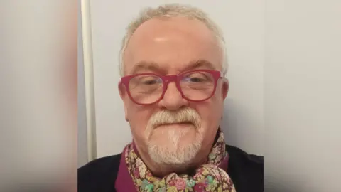 Jude Whyte Jude Whyte - A man with white hair and goatie wearing red glasses taking a selfie