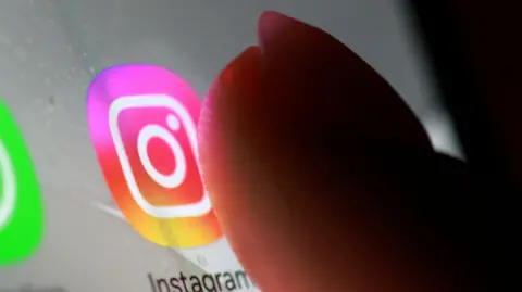 Reuters A finger taps the screen of a device to access Instagram.