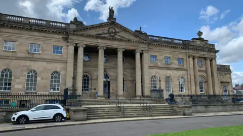 Exterior of York Crown Court, a stone building with four pillars. 