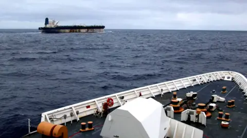 The shadow fleet ship Marinera seen in the distance from the upper decks of a US coastguard cutter following her.