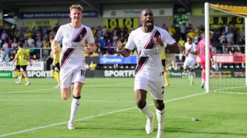 Chris Vaughan/Getty Images Tendayi Darikwa, right, of Lincoln City, celebrates scoring his side's second goal with teammate JJ McKiernan during the League One match between Burton Albion FC and Lincoln City FC
