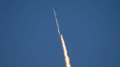 Getty Images Spaceship rocket launches into space with a trail of fuel behind it