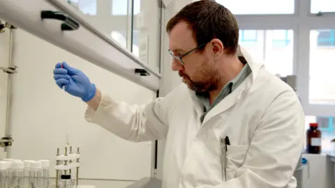 University of Southampton A male scientist in a lab looking at a sample 