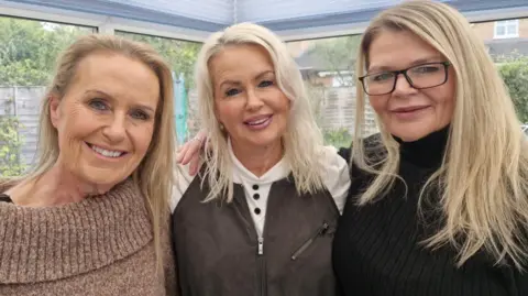Sisters Karen Falconer 57, Jacqueline Falconer, 59, Nicola Falconer, 53, are gathered together for a photographer in a conservatory. 