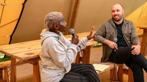 Sarah Hewitt Two people with microphones talk to each other