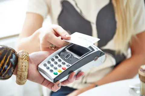 A woman paying using a card