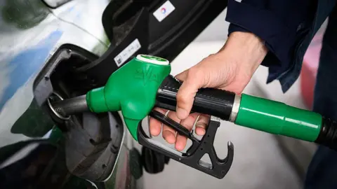 A driver fills up their car with petrol.