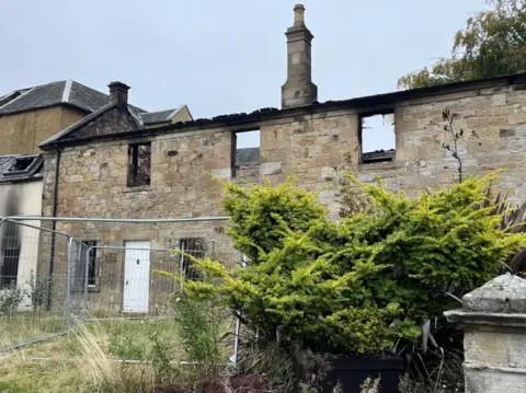 Part of the hotel building with the roof burned off