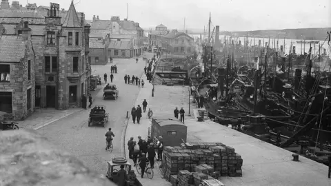 Shetland Museum & Archives A busy harbour in Lerwick Shetland in the 1920's. Dozens of drifters are docked. 